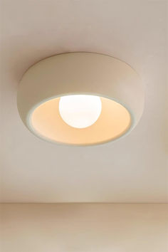 a round light fixture in a white room