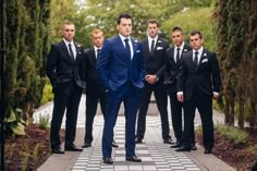 a group of men in suits and ties standing next to each other on a walkway