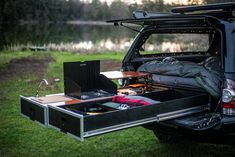 an open trunk in the back of a truck with camping gear on it's bed