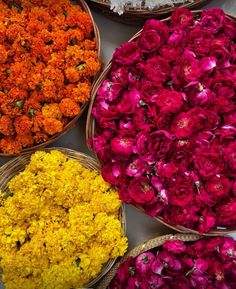 baskets filled with different colored flowers on top of a table