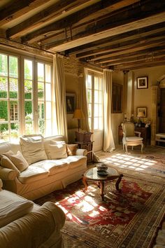 a living room filled with furniture and windows covered in sun shining through the window panes