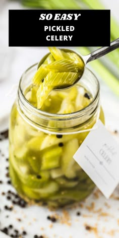 pickled celery in a glass jar with a spoon and label on it