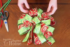 someone is making a christmas bow out of wrapping paper