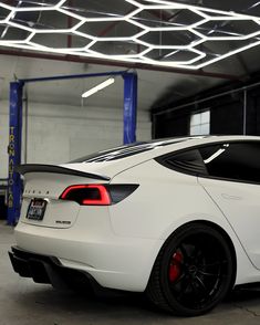 a white sports car parked in a garage