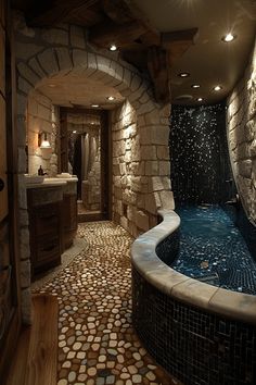 a bathroom with stone walls and flooring next to a large tub in the middle of it