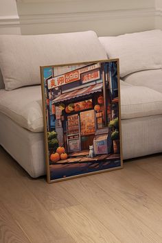 a couch sitting next to a painting on top of a hard wood floor in front of a white couch