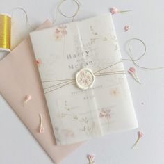 a wedding album with a ring on it and confetti scattered around the pages