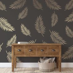 a wooden table sitting in front of a wall with a plant pattern on the wall