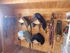 there are many hats hanging on the wall in this room with wood paneled walls