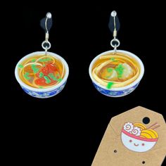 two bowls of soup with chopsticks and gummy bears in them on a black background