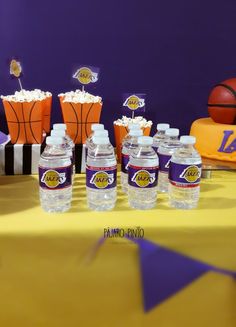 water bottles are sitting on a table with basketballs and cupcakes in the background