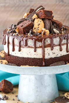 a chocolate cake with cookies and oreo cookies on top is sitting on a silver platter