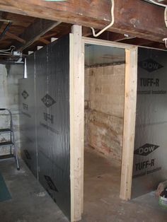 an unfinished room that is under construction with the door open and insulation taped up on the walls