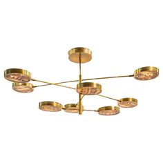 a large brass chandelier with six lights on each end and five circular glass shades