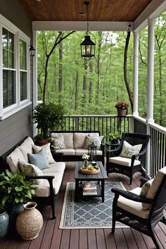 a porch with chairs, tables and couches on it in front of some trees