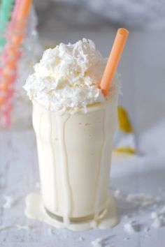 a drink with whipped cream and two orange straws