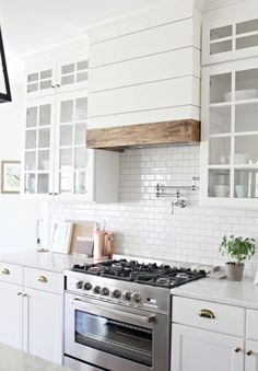 a kitchen with white cabinets and an oven