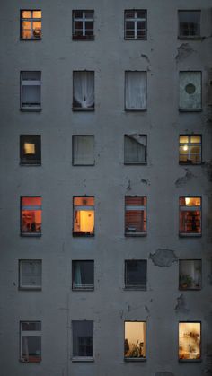 an apartment building with many windows lit up at night