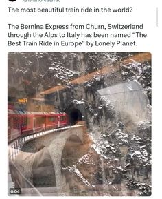 an image of a train going through a tunnel with snow on the mountains behind it