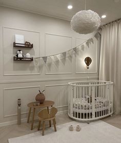 a baby's room with a white crib and wooden stools on the floor