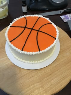 a birthday cake with a basketball design on the top is sitting on a wooden table