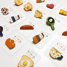 a bunch of magnets that are on top of a white table with food in them