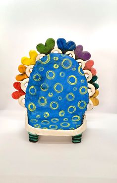 a blue and yellow toy with lots of circles on it's back end, sitting in front of a white background