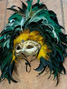 This large gorgeous Mardi Gras mask is green and gold and white, with papier-mâché face. Hand painted hand feathered headdress.  Large feathered mask made by New Orleans premier maskmaker. Made by hand by local French Quarter artist for Mardi Gras parades, balls, masquerades, or your occasion. Our masks also come ready to display on your wall or mask stand.  Lightweight and comfortable. Beautiful jewel in center of forehead.  This beautiful one of a kind mask would look stunning on men or women for your event.  We do custom work and would love to talk to you about your wedding or birthday or masquerade. 20 years experience making masks for all sorts of special occasions. We can even make changes to the masks currently for sale. Message or call and ask, please. We want to make a mask you lo Feathered Mask, Feathered Headdress, Mardi Gras Parade, New Orleans Mardi Gras, Feather Headdress, Mardi Gras Mask, French Quarter, Beautiful One, Mask Making