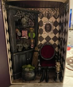 the doll house is decorated in black and white checkerboard with red velvet chair