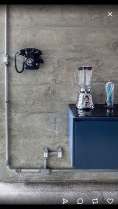 a blue cabinet sitting next to a wall with a blender on top of it