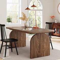 a dining room table with two chairs and a vase