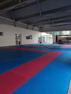 an indoor gym with blue and red mats