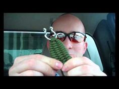 a man holding up a green object in his hand while sitting in the back seat of a car