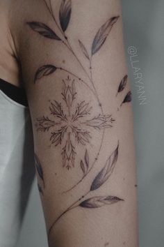 a woman's arm with a flower tattoo on it