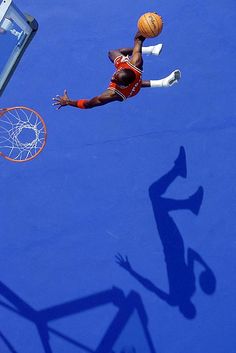 a basketball player is in mid air after dunking the ball