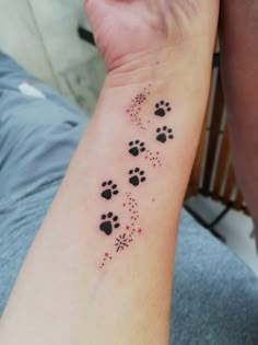 a person with a tattoo on their arm that has paw prints and stars all over it