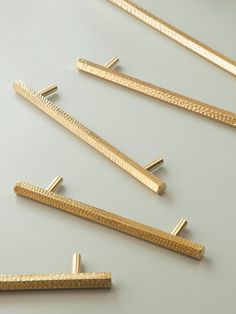 several pieces of gold colored metal on a white surface