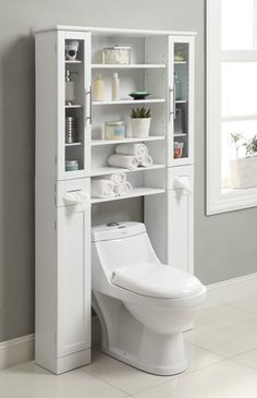 a white toilet sitting next to a tall cabinet