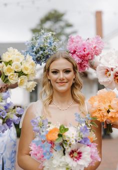 a woman standing in front of a bunch of flowers