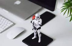 a star wars figurine sitting on top of a desk next to a keyboard