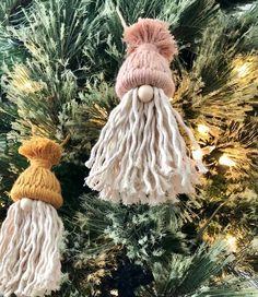 two knitted ornaments hanging from a christmas tree in the shape of santa claus's hat