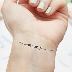 a woman's arm with a small tattoo on it that says love and two birds