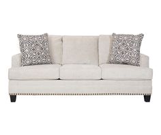 a white couch with pillows on top of it and some black and white decor around the edges