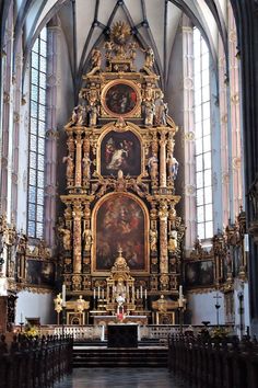 an ornate alter in a church with paintings on the walls