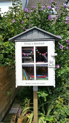 a little library in the middle of some flowers