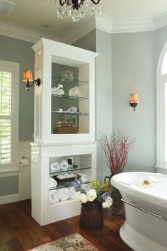 a bathroom with a sink, toilet and bathtub in the corner next to a chandelier