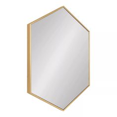 a mirror that is on top of a white wall with gold trim and a hexagonal frame