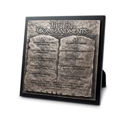 the ten commandments book cover mounted on a black frame with an image of two stone tablets