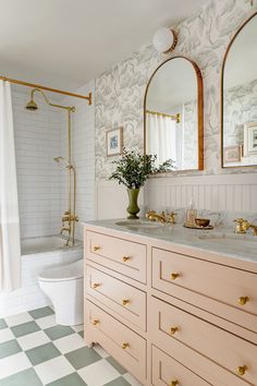 a bathroom with two sinks, a toilet and a bathtub in the middle of it