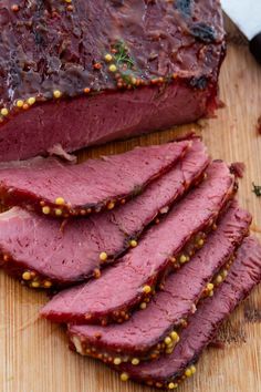 sliced meat sitting on top of a wooden cutting board